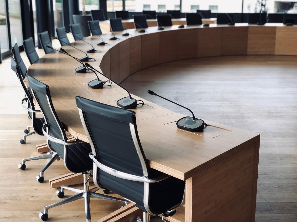 Raadszaal tafel met microfoons en stoelen 